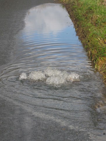 Bubbling drainage next to grass verge