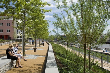 People sitting on bench overlooking grassy verge and river