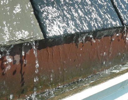 Rainwater running off roof tiles into gutter