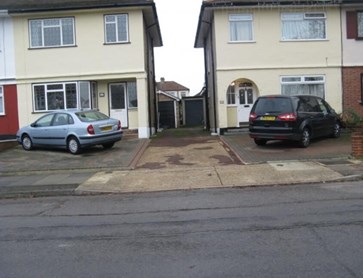 Terraced houses with cars parked on paved front gardens