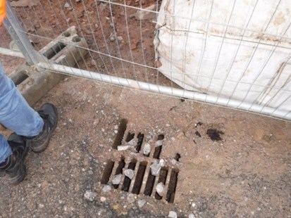 Silt and stones in road drain on construction site